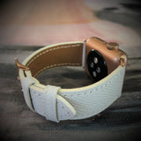 Textured White Apple Watch Band by Juxli Home.  Handmade, stylish leather strap with rose gold hardware on a 40mm Apple watch on a canvas with a black and gray painting.