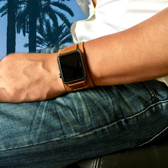 Caramel Brown Apple Watch Leather Cuff by Juxli Home.  Handmade, stylish leather strap with rose gold hardware on a 40mm Apple watch on a canvas with a black and gray painting.